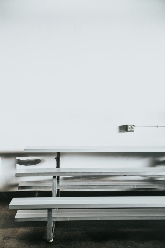 gray bench near white wall