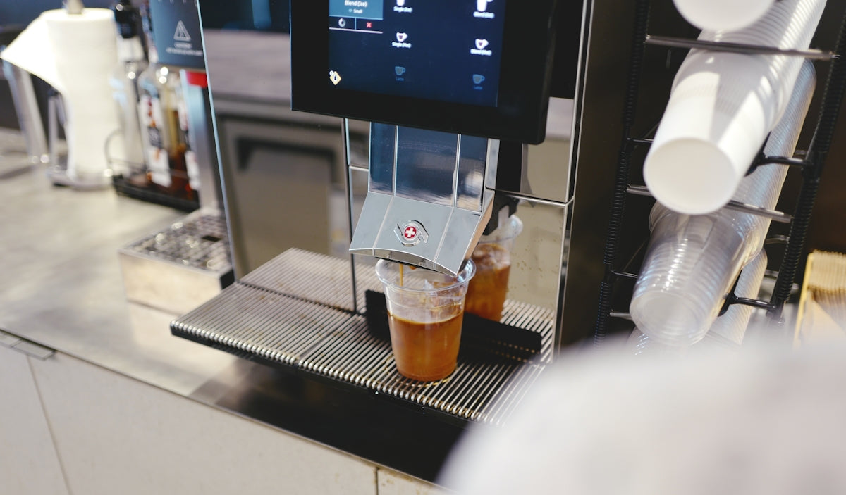 a coffee machine with two cups of coffee on it