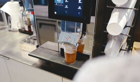 a coffee machine with two cups of coffee on it