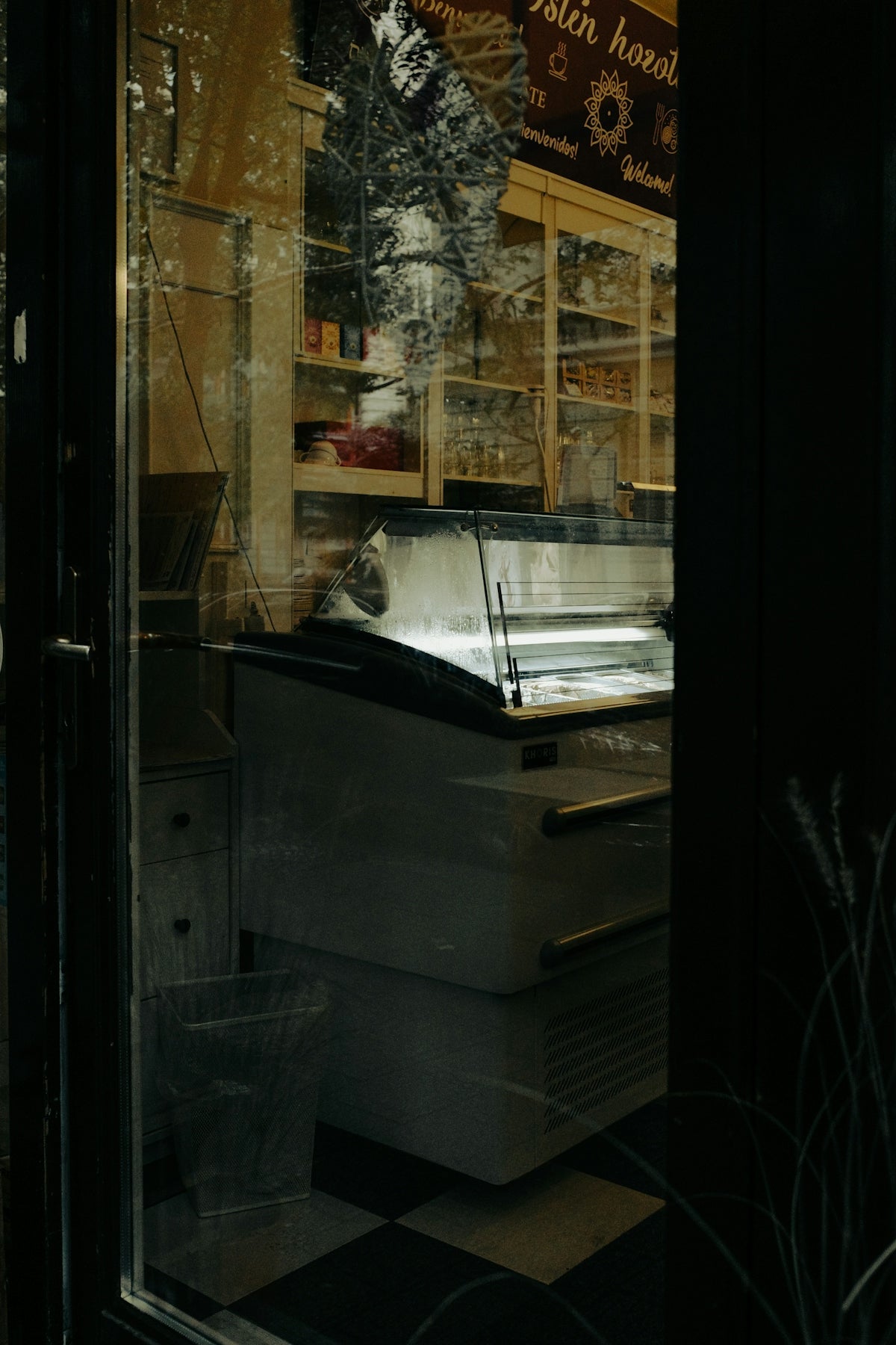 A store front with a window that has a food cart in it