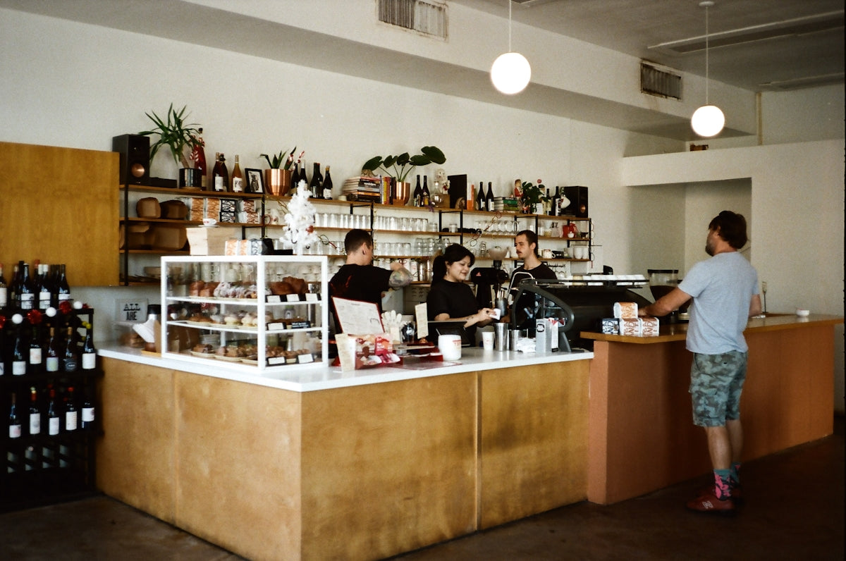 A man standing in front of a counter filled with bottles of wine