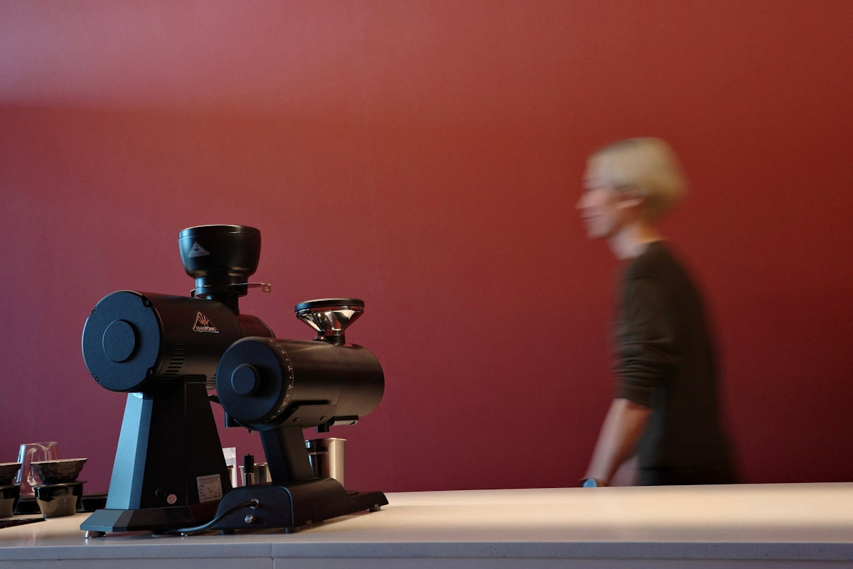 Coffee grinders are set up with a person walking.