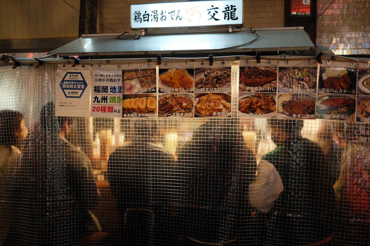 People queue at a japanese food stall.