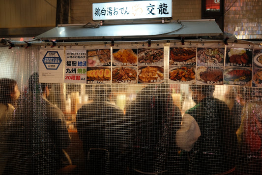 People queue at a japanese food stall.