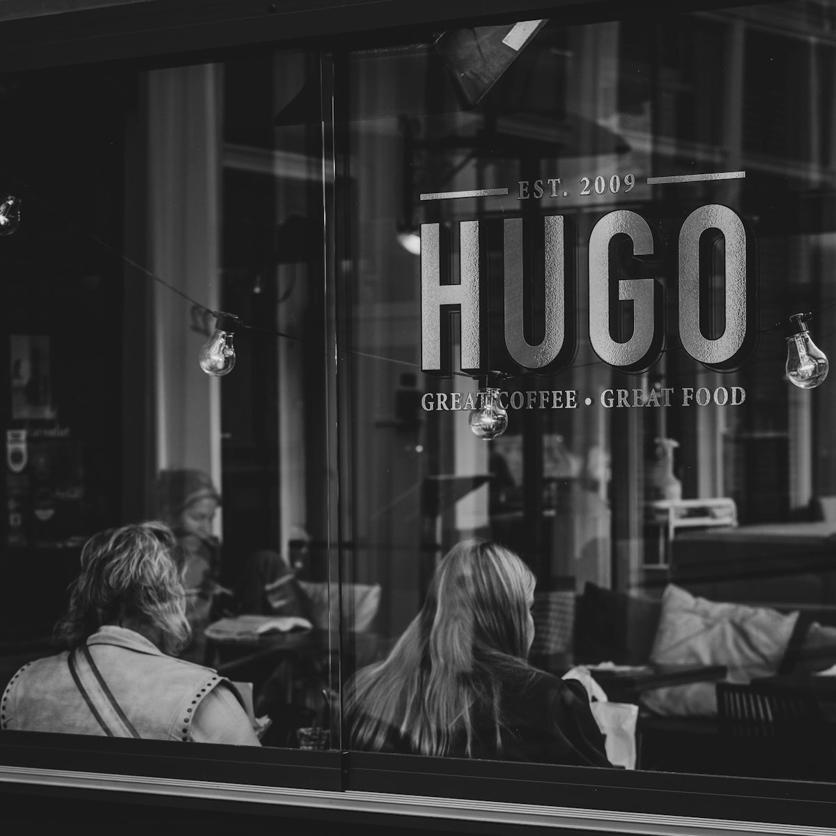 People sitting inside a cafe seen through window